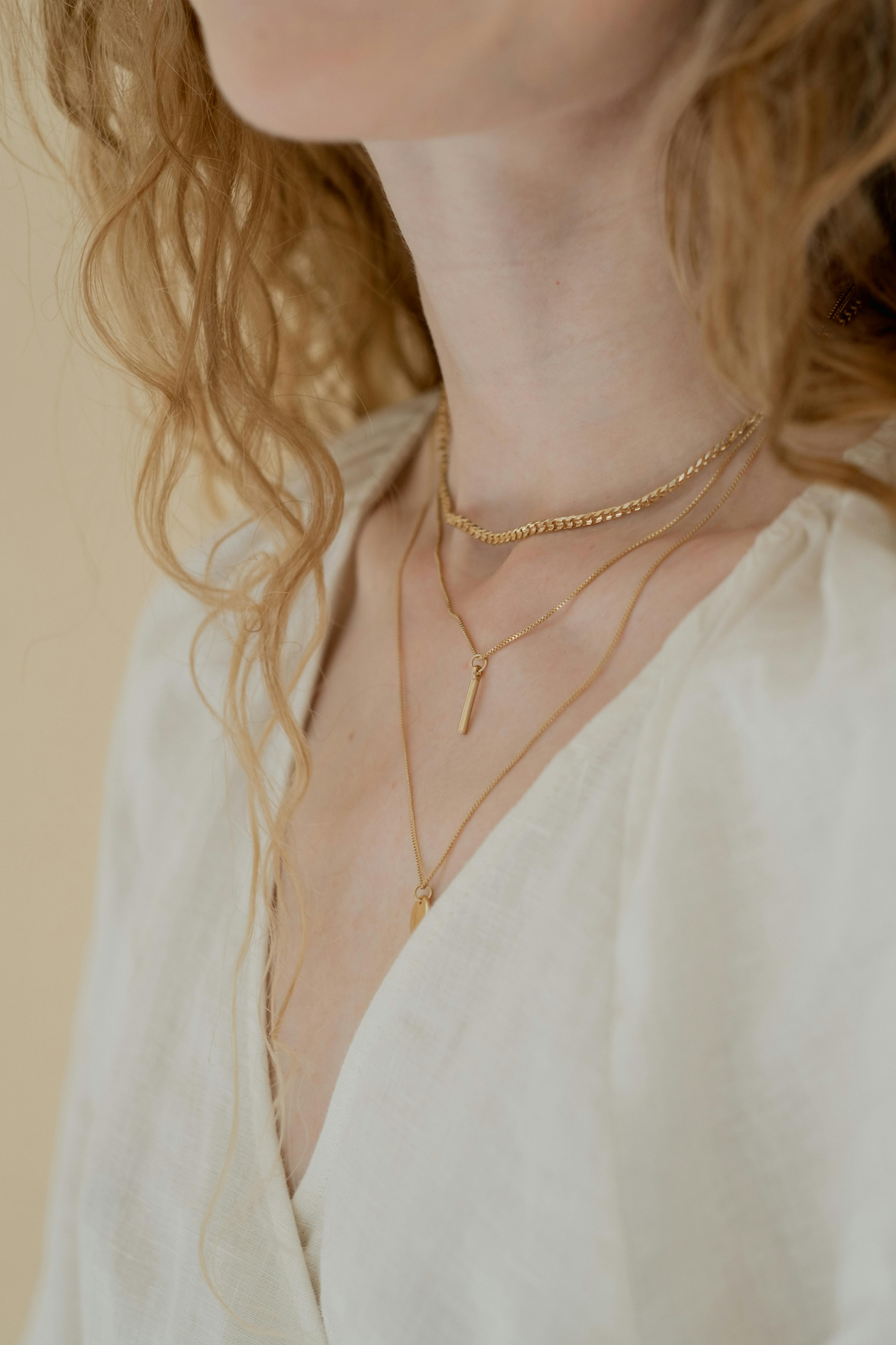 Layered necklaces worn on a light outfit