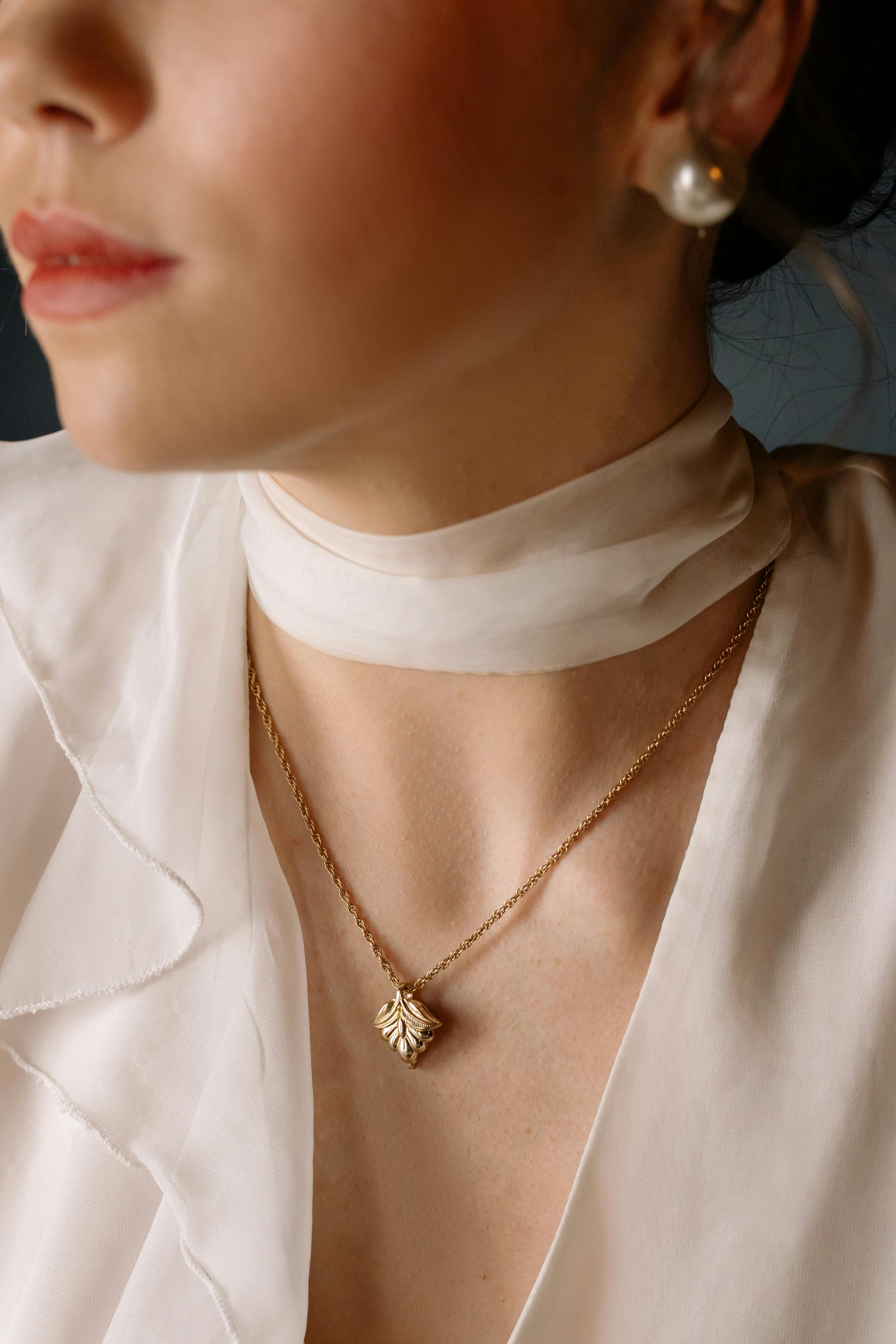 Gold pendant necklace worn on a light outfit